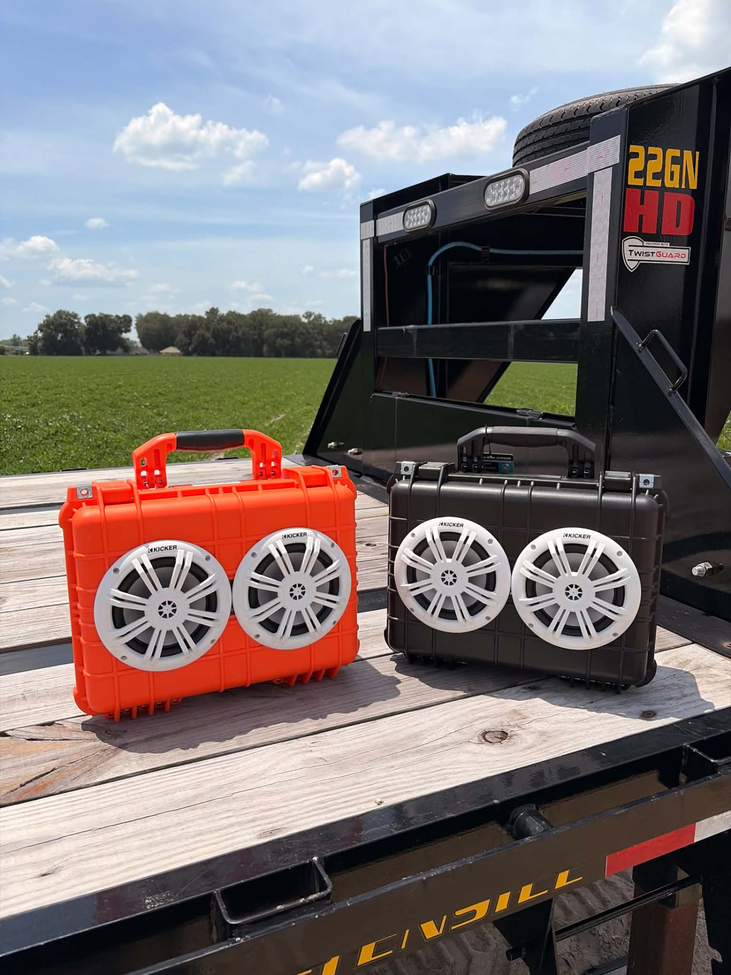 Handmade rugged outdoor speaker boxes on a trailer by a field